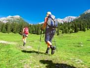 Zwei Wanderer in einer Almlandschaft mitten in den Bergen
