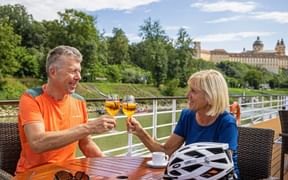 A couple with Aperol on the ship's terrace, Melk Abbey in the background