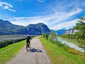 Cyclist rides along the beautiful Adige river