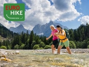 Hikers cross the inlet of Lake Jasna