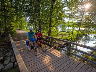 Zwei Radfahrer auf einer Brücke im Wald am Ostersee