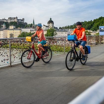 Cyclists on the Makartsteg with Salzburg's old town in the background